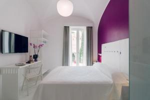 a bedroom with a white bed and white walls at Ravello In in Ravello
