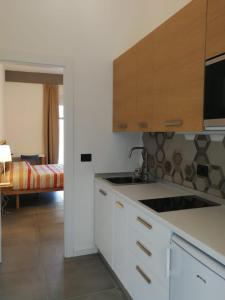 a kitchen with white cabinets and a sink at Timpa b&b in Pizzo