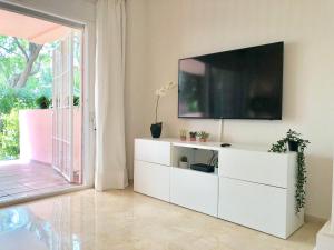 a living room with a television on a white dresser at Apartamento Guadalmina - Golf & Playa - Marbella in Marbella