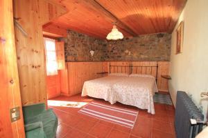 a bedroom with a bed in a stone wall at La Llosa II in Villaviciosa
