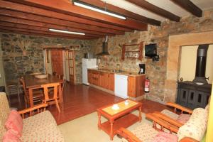 cocina y sala de estar con mesa y fogones en La Llosa II, en Villaviciosa