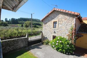 a stone house with a garden and a fence at La Llosa II in Villaviciosa