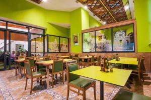 a restaurant with yellow walls and tables and chairs at Hotel Julia in Madrid