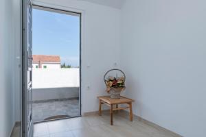 eine Glastür, die auf einen Balkon mit einer Blumenvase führt in der Unterkunft Apartments Marković in Stari Grad
