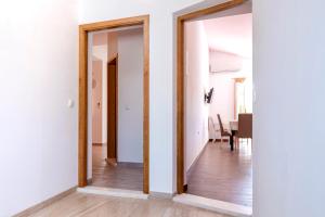 a hallway with two mirrors and a dining room at Apartments Marković in Stari Grad