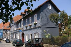 une petite voiture garée devant une maison bleue dans l'établissement Gästehaus Schmitz, à Goslar