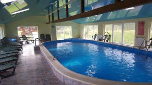 Una gran piscina en un edificio con sillas. en Casa Siady, en Vatra Dornei