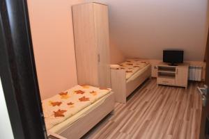 Cette chambre comprend 2 lits et une télévision. dans l'établissement Dom Weselny Jagiełło, à Dobrzelin