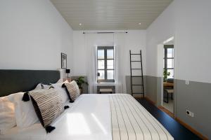una camera da letto con un grande letto bianco con cuscini di Argonauta Hotel a Paroikia