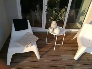 a white chair and a table on a porch at Dru-Sky in Druskininkai