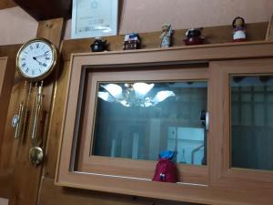 a clock on top of a cabinet with a window at Hanok Guesthouse Nuha in Seoul