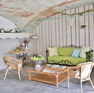 a living room with a green couch and a table at Tenuta Ajrale in Vigone