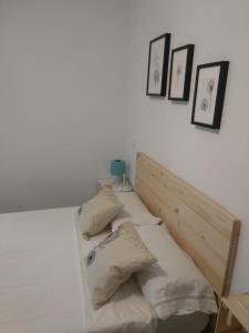 Un dormitorio con una cama con almohadas. en Apartamentos Ciempozuelos, en Ciempozuelos