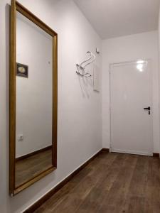 un espejo en una pared blanca al lado de una puerta en Apartamentos Ciempozuelos en Ciempozuelos