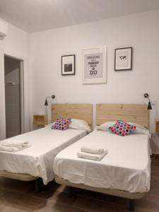 two beds sitting next to each other in a bedroom at Apartamentos Ciempozuelos in Ciempozuelos