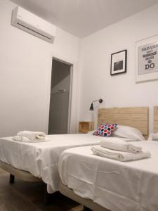 a bedroom with two beds with towels on them at Apartamentos Ciempozuelos in Ciempozuelos