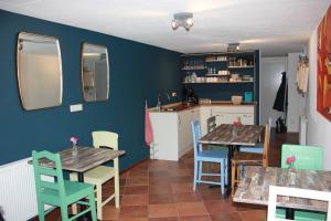 a kitchen and dining room with two tables and chairs at Bluesheep-texel in De Koog