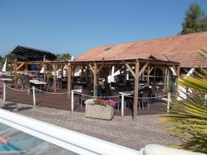 a restaurant with tables and chairs on a deck at mobilhome charme funpass et wifi inclus in Gastes