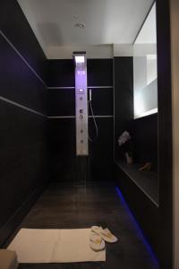 a black bathroom with a shower with a pair of shoes at Reginna Palace Hotel in Maiori