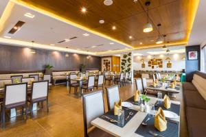 a restaurant with tables and chairs and a bar at Sugar Business Hotel in Cochin