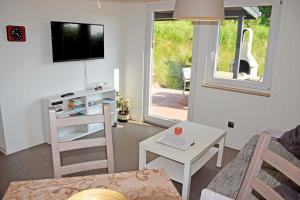 a living room with a couch and a table and a tv at Ferienhaus in Goehren in Göhren