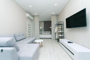 キーウにあるApartment in Smart Plazaのリビングルーム(白い家具、薄型テレビ付)