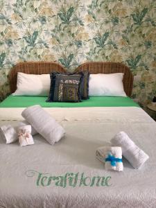 un letto con due cuscini e asciugamani di Pompei TERAFI Home a Pompei
