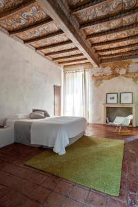 a bedroom with a large bed and a green rug at Corte Mainolda in Castellucchio