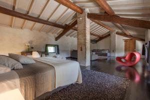 ein Schlafzimmer mit einem großen Bett und einem roten Stuhl in der Unterkunft Corte Mainolda in Castellucchio