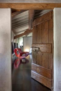 a red chair in a room with a wooden door at Corte Mainolda in Castellucchio
