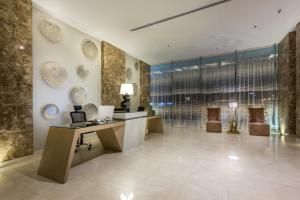 a lobby with a desk and plates on the wall at Ewaa Express Hotel - Al Hamra in Jeddah