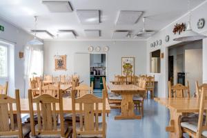 una sala da pranzo con tavoli e sedie in legno di STF Vandrarhem Sälen a Stöten