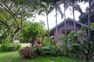 七岩的住宿－班克拉托姆桐海濱度假屋，一座粉红色的房子,前面有棕榈树