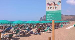eine Menschenmenge, die auf Liegestühlen am Strand sitzt in der Unterkunft Villa Dei Principi Hotel in Terracina