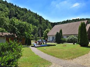 a group of people sitting in a yard next to a house at Combined flat on a farm in Kellerwald in Bad Wildungen