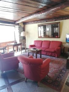 a living room with red couches and a table at Hotel Tavernier in Courmayeur