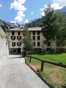 un bâtiment avec une clôture devant lui dans l'établissement Hotel Tavernier, à Courmayeur