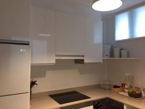 a kitchen with white cabinets and a window at Apartamento turístico en pleno centro de Ferrol in Ferrol