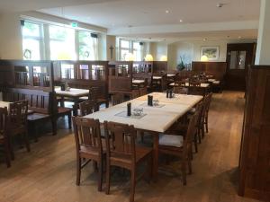 a dining room with tables and wooden chairs at Brauereigaststatte Spitalgarten in Regensburg