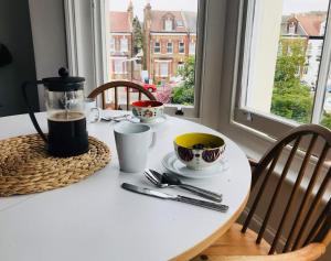 Biały stół z dwoma filiżankami kawy na nim w obiekcie Margate Holiday Apartment w mieście Margate
