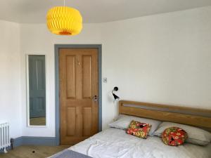 a bedroom with a bed with a wooden headboard and a door at Margate Holiday Apartment in Margate