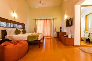 a large room with two beds and a television at Regenta Resort Soma Vine Village Nashik in Nashik