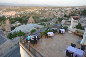 a group of people sitting at tables on a patio with a view at Hotel Lalesaray in Uçhisar