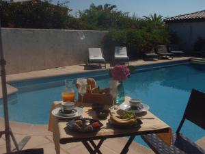 a tray of food on a table next to a pool at Le Jardin d Eden in Sainte-Maxime