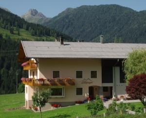 a large house with a balcony and mountains in the background at Gästehaus Lanzinger in Liesing