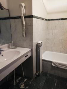 a bathroom with a sink and a bath tub at Hotel Tavernier in Courmayeur