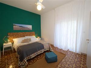 1 dormitorio con cama y pared verde en Il bracconiere en Fonteblanda