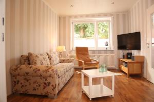 ein Wohnzimmer mit einem Sofa und einem TV in der Unterkunft Ferienhaus Witte Huuske in Emden