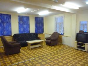 アルハンゲリスクにあるДом с мансардойのリビングルーム(ソファ、椅子、テレビ付)