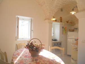 una cocina con una mesa con una cesta de flores. en Casa Indipendente Settecentesca AIRCON Wifi Vista Mare, en Ostuni
